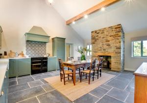 a kitchen with a table and chairs and a fireplace at Rocks Cottage in Builth Wells