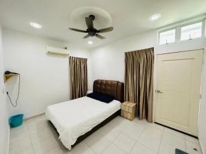 Paddy Village Multi Homestay في سيكينتشان: غرفة نوم بسرير ومروحة سقف