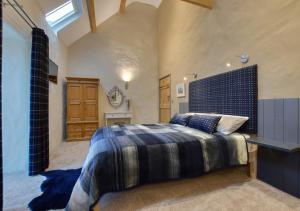 a bedroom with a large bed with a blue headboard at Tyddyn Iago in Llangwnadl