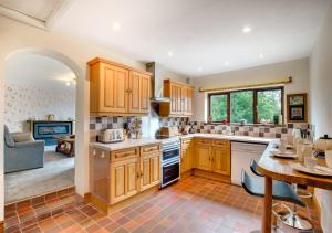 a kitchen with wooden cabinets and a living room at Top Y Nant in Mold