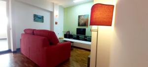a living room with a red chair and a television at Bella Vista in Syracuse