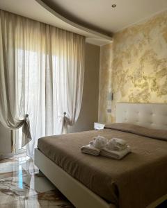 a bedroom with a bed with two pairs of shoes on it at B&B Narcisse in Tropea