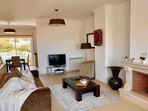 ein Wohnzimmer mit Couch und Kamin in der Unterkunft Fantástico T2 vista mar e golfe e terraço privado C5 in Vau
