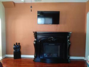 a black fireplace with a television on a wall at Bungalow Haven in Winter Haven