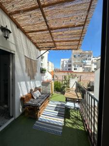 a balcony with a bench and a wooden pergola at Prado Design Apartment in Gandía