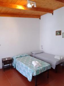 2 Betten in einem Zimmer mit Holzdecke in der Unterkunft Casa vacanza Ligustro appartamento il toro in SantʼAntìoco