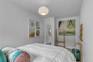 a white bedroom with a bed and a chandelier at Duke Street brand new central 1 bed flat in Norwich