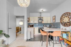 a kitchen with white cabinets and orange chairs at Duke Street brand new central 1 bed flat in Norwich