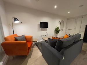 a living room with two couches and a television at 1-Bedroom Apartments in the Heart of Central Woking in Woking