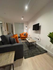 a living room with a couch and a table at 1-Bedroom Apartments in the Heart of Central Woking in Woking