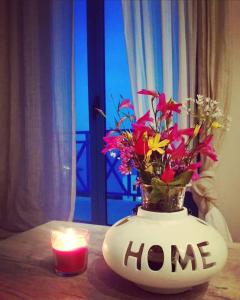 a vase filled with flowers and a candle on a table at La casa azul in Megalochori