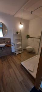 a bathroom with a tub and a toilet and a sink at Landhaus Bondzio in Langen Brütz +25 photos