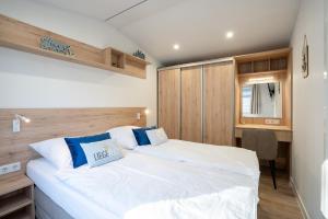 a bedroom with a large white bed and a desk at Ostseecamp Lübecker Bucht Ferienhaus "Min Tohuus" in Scharbeutz
