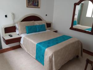 Hotel Zulita في بوغوتا: غرفة نوم بسرير كبير ومرآة