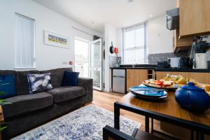 a living room with a couch and a table at Little Waves in St Ives