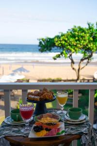 uma mesa com comida e bebidas e a praia em Maravista Hotel & Spa Ltda em Búzios