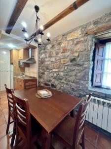 Una cocina y un comedor con mesa y sillas de madera. en Casas Rurales Las Corradas, en Éndriga