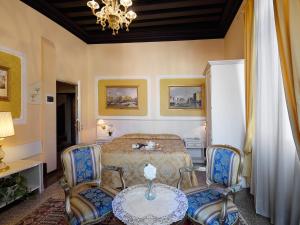 1 Schlafzimmer mit einem Bett, 2 Stühlen und einem Tisch in der Unterkunft Hotel Corte dei Greci in Venedig