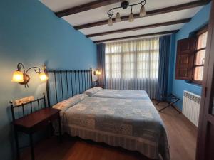 Un dormitorio con una cama y una mesa y una ventana. en Casas Rurales Las Corradas, en Éndriga
