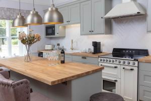a kitchen with white cabinets and a wooden counter top at The Manor House at Norton Park in Winchester