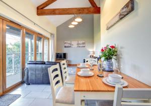 a dining room and living room with a wooden table and chairs at Y Fro - The Vale in Barry