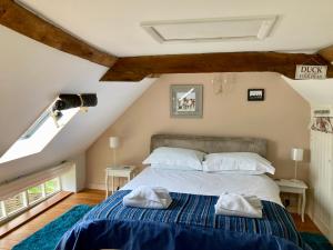 a bedroom with a bed with two towels on it at Simpers Drift, Great Glemham in Saxmundham