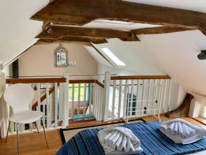 a attic bedroom with a bed and a chair at Simpers Drift in Saxmundham