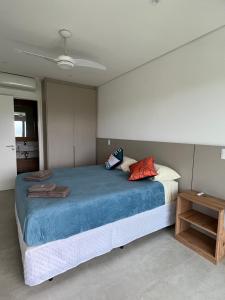 ein Schlafzimmer mit einem großen Bett und einem Tisch in der Unterkunft Vista maravilhosa na Riviera in Riviera de São Lourenço + 10 Fotos