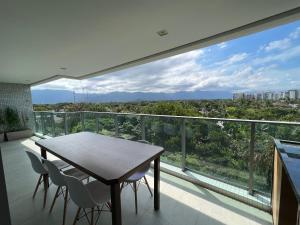 ein Tisch und Stühle auf einem Balkon mit Aussicht in der Unterkunft Vista maravilhosa na Riviera in Riviera de São Lourenço