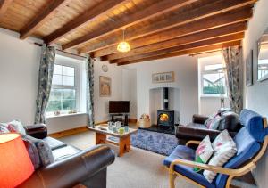 a living room with leather furniture and a fireplace at West End Cottage in Llangennith