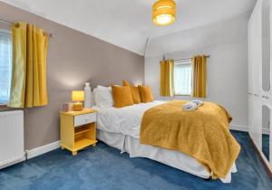 a bedroom with a large bed with yellow curtains at Valley Rise By My Getaways Free Parking in Portslade