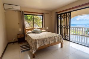 a bedroom with a bed and a large window at OCEAN VISTA in Au Cap