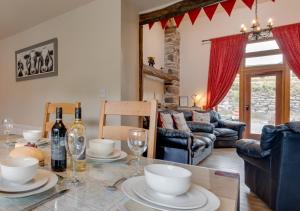 a living room with a table with wine bottles and glasses at Ysgubor y Berwyn in Llanarmon Dyffryn-Ceiriog