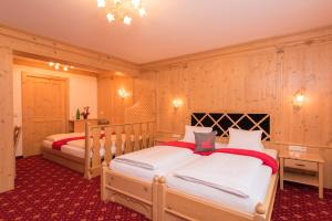 two beds in a room with wooden walls at Hotel Mölltalerhof in Rangersdorf