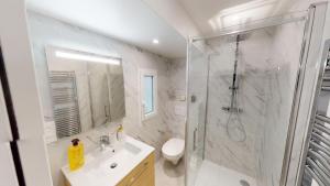 uma casa de banho com um chuveiro, um lavatório e um WC. em La Comtesse De Montespan em Le Chesnay