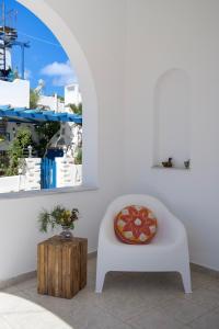 une chaise blanche avec un oreiller et une boîte en bois dans l'établissement Eva House Dryos Beach Paros, à Drios