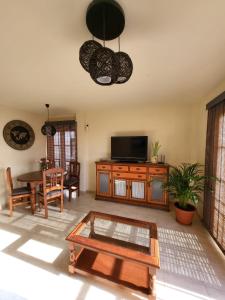 uma sala de estar com uma televisão e uma mesa de centro em Apartment next to Ajabo Beach Pool & Ocean view em Callao Salvaje