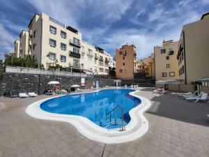 a large swimming pool in the middle of a building at Apartment next to Ajabo Beach Pool & Ocean view in Callao Salvaje