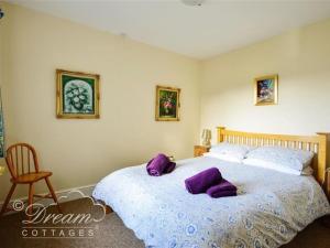 een slaapkamer met een groot bed met paarse kussens bij Frome Lodge House in Dorchester