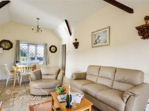 una sala de estar con un sofá y una mesa en Frome Lodge House, en Dorchester