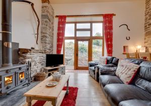 a living room with a couch and a fireplace at Ystabl y Berwyn in Llanarmon Dyffryn-Ceiriog