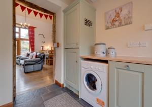 eine Küche und ein Wohnzimmer mit Waschmaschine und Trockner in der Unterkunft Ystabl y Berwyn in Llanarmon Dyffryn-Ceiriog