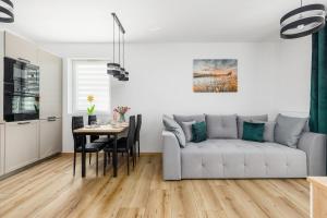 uma sala de estar com um sofá branco e uma mesa em Pet friendly Apartment Górna 31 by Renters em Ustronie Morskie