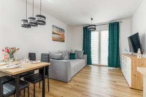 uma sala de estar com uma mesa e um sofá em Pet friendly Apartment Górna 31 by Renters em Ustronie Morskie