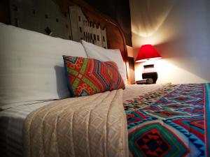 ein Schlafzimmer mit einem Bett mit einem Kissen und einer Lampe in der Unterkunft Hotel Chocolate Tradicional in Guanajuato