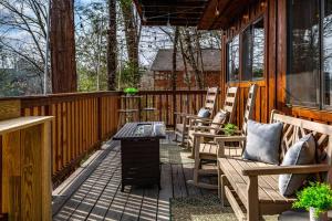 eine Veranda mit Stühlen und einem Tisch auf einer Hütte in der Unterkunft The Family Stone Luxe Cabin Sleeps 12 Hot tub Dogfriendly Dollywood in Pigeon Forge