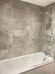 a bathroom with a shower and a bath tub at Cosy Bedrooms in Manchester