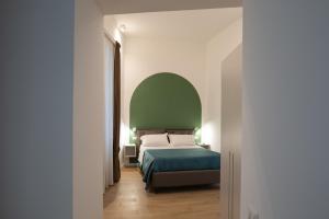 a bedroom with a bed and a green wall at Relais Palazzo Olimpia - Corso Vittorio Emanuele in Salerno