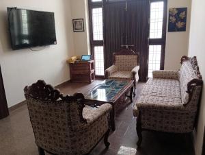a living room with two chairs and a coffee table at VRINDA Kunj ASHRAYAM in Vrindāvan