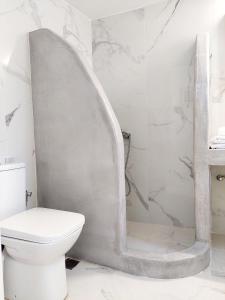La salle de bains blanche est pourvue d'une douche et de toilettes. dans l'établissement Eva House Dryos Beach Paros, à Drios